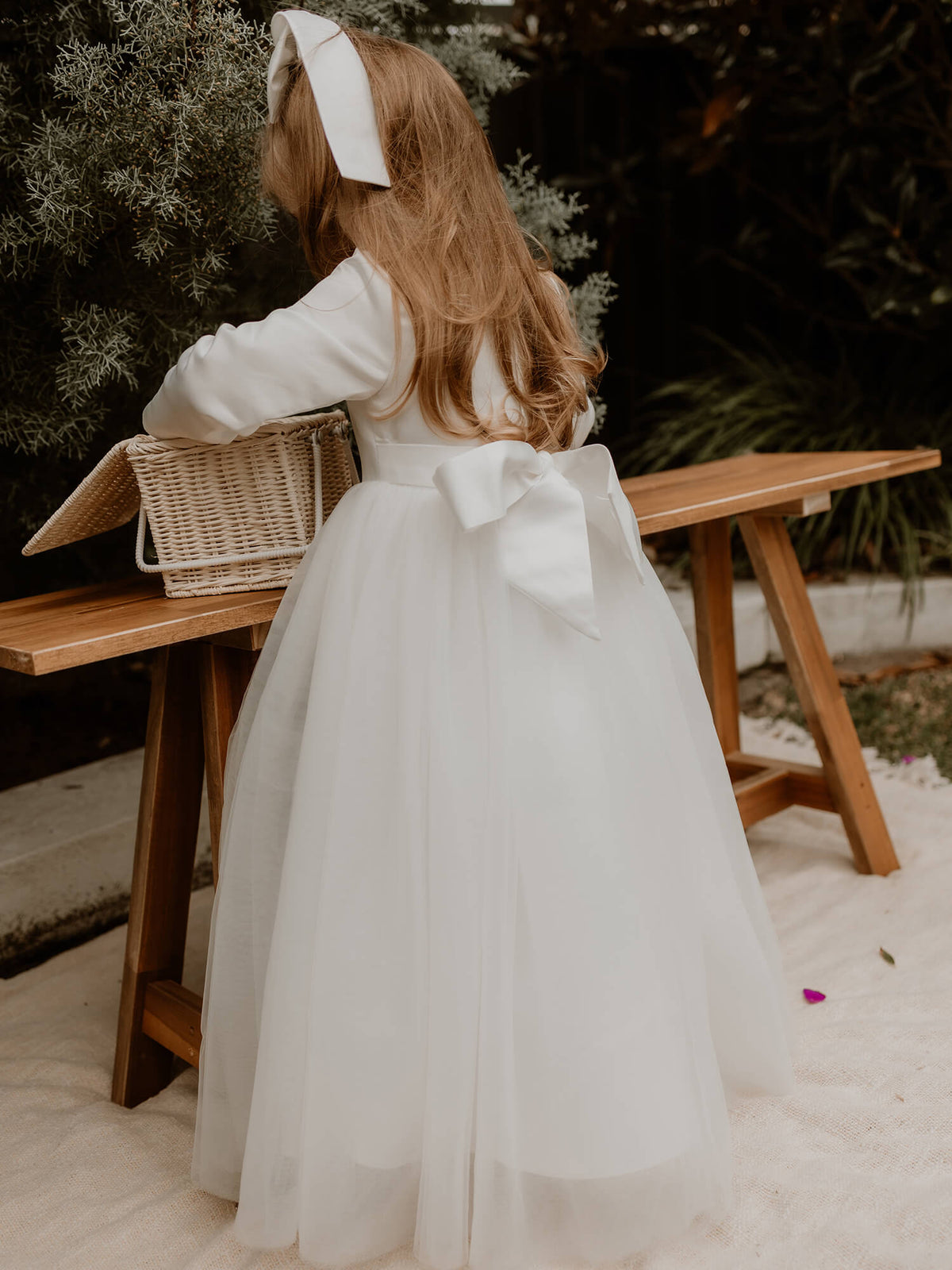 Lucy winter flower girl dress shown from the back, showing the large satin bow and full length tulle skirt.