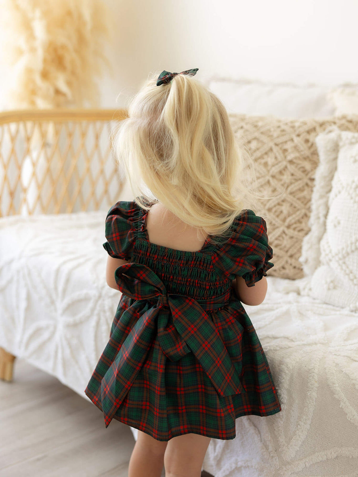 The back of our Mila romper showing the shirring and bow in our Christmas plaid print.