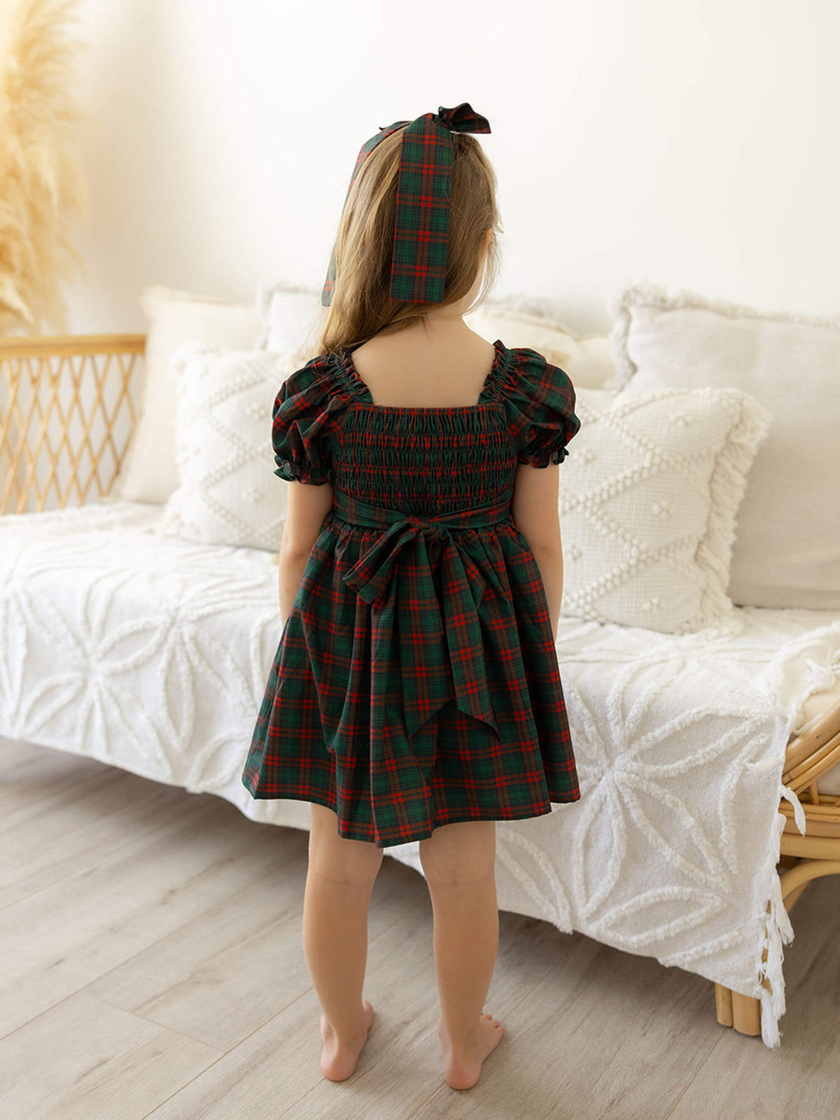 The back of our Mila Christmas plaid girls dress and matching girls hair bow.