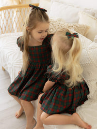 Mila Christmas plaid girls dress & matching romper are worn by two sisters.