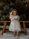 Pippa floral flower girl dress is worn by a young girl, showing the dainty floral lace.
