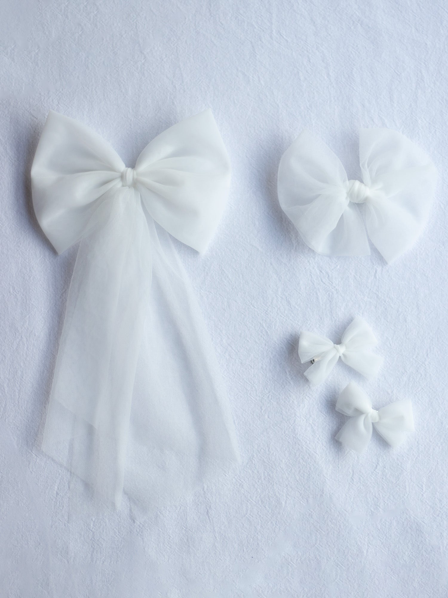 Girls ivory tulle bows. Our large tulle bow clip, medium tulle bow clip and small pigtail bow clips.