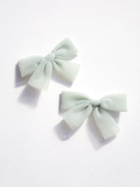 Small tulle pigtail bows in sage green.