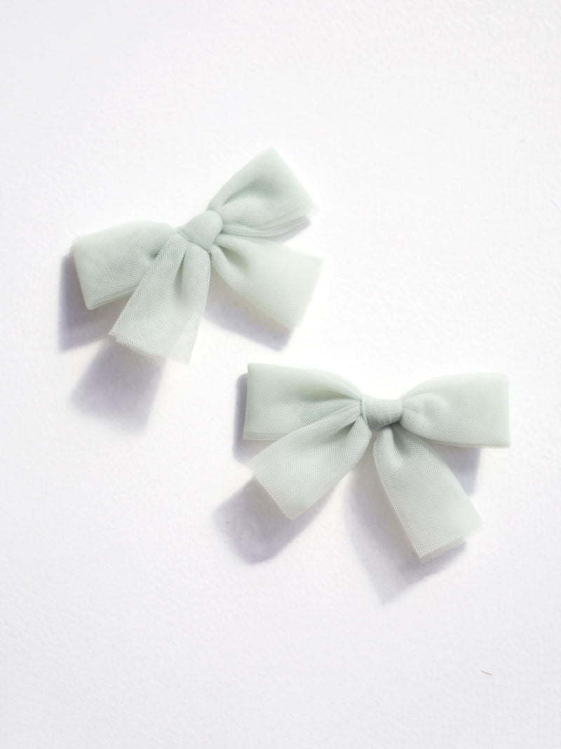 Small tulle pigtail bows in sage green.