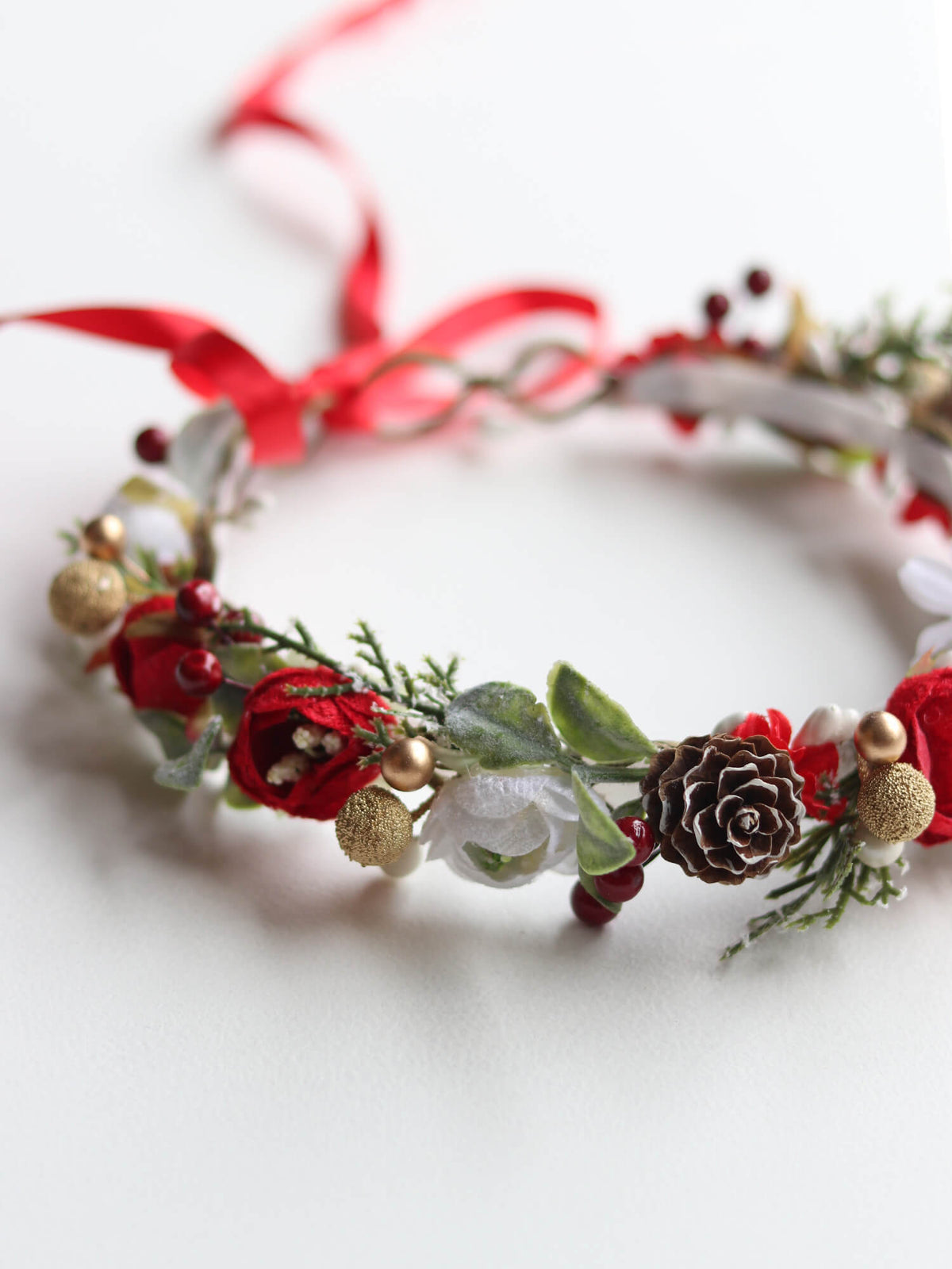 Winter Christmas flower crown with red and ivory florals, gold accents and greenery.