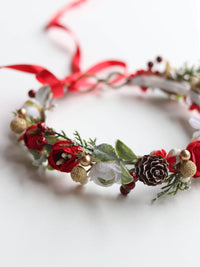 Winter Christmas flower crown with red and ivory florals, gold accents and greenery.