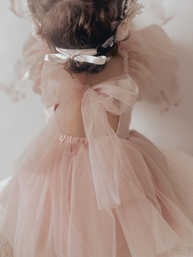 Tulle bow back detail of our Wren baby flower girl romper in dusty pink.