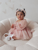 Wren dusty pink flower girl romper is worn by a toddler. She also wears our blush Rose flower crown.