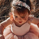 Toddler wearing our Amelie baby floral headband flower crown and Everly dusty pink tulle romper.