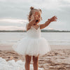 Everly lace special occasion romper in ivory being worn by a toddler.