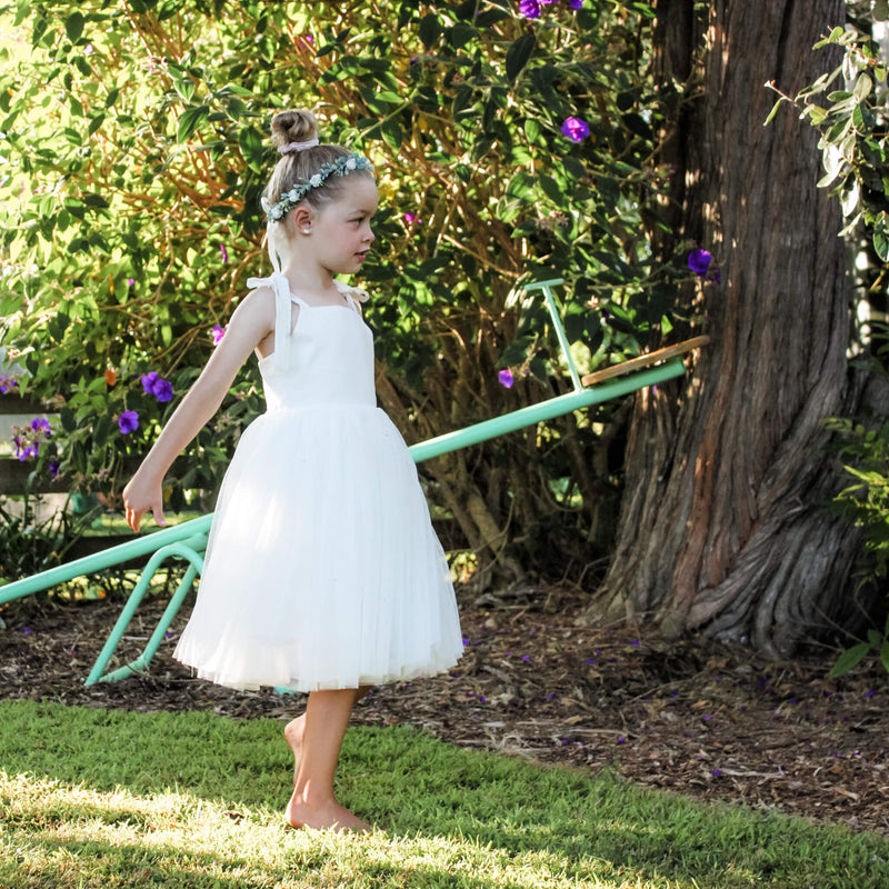 Margot ivory tulle flower girl dress being worn by a young girl. She also wears our Eden flower crown.