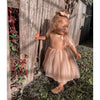 Rosie tulle girls party dress shown on a young toddler. The champagne flower girl dress has tulle straps and a tulle skirt.