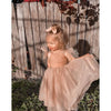 Rosie flower girl dress worn by a toddler. The tulle dress has tulle bow straps and is Champagne in colour.