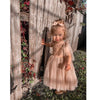 Rosie tulle tie flower girl dress being worn by a toddler who is standing outside. One of our tulle flower girl dresses, the dress is tied with tulle straps in bows at the shoulder.