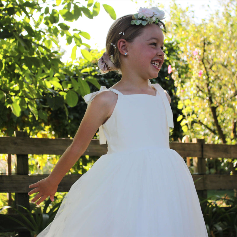 Flower girl wears our Grace girls blush flower crown and Sonnet flower girl dress with tie straps.