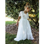 Violette lace flower girl dress worn by a child. The eyelash lace if full length, with flutter sleeves and a lace feature back.