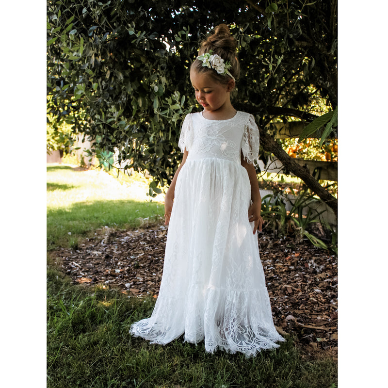 Full length lace girls dress, our Violette flower girl dress, being worn by a young girl. Along with an ivory flower crown, our Delilah floral headband.