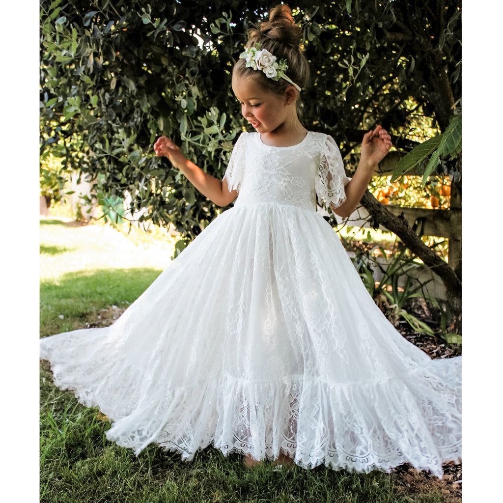 Violette ivory lace flower girl dress worn by a young girl, along with our Delilah ivory floral headband.