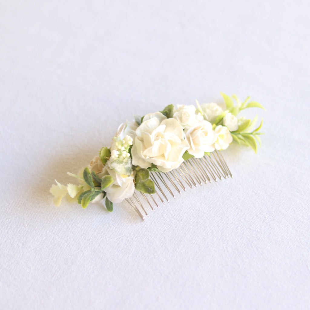 Ava girls ivory floral comb being worn by a young flower girl. She wears a low wedding up-do with the comb centered above it.