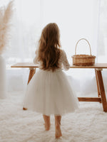 Belle tea length flower girl dress shown from the back on a young girl.