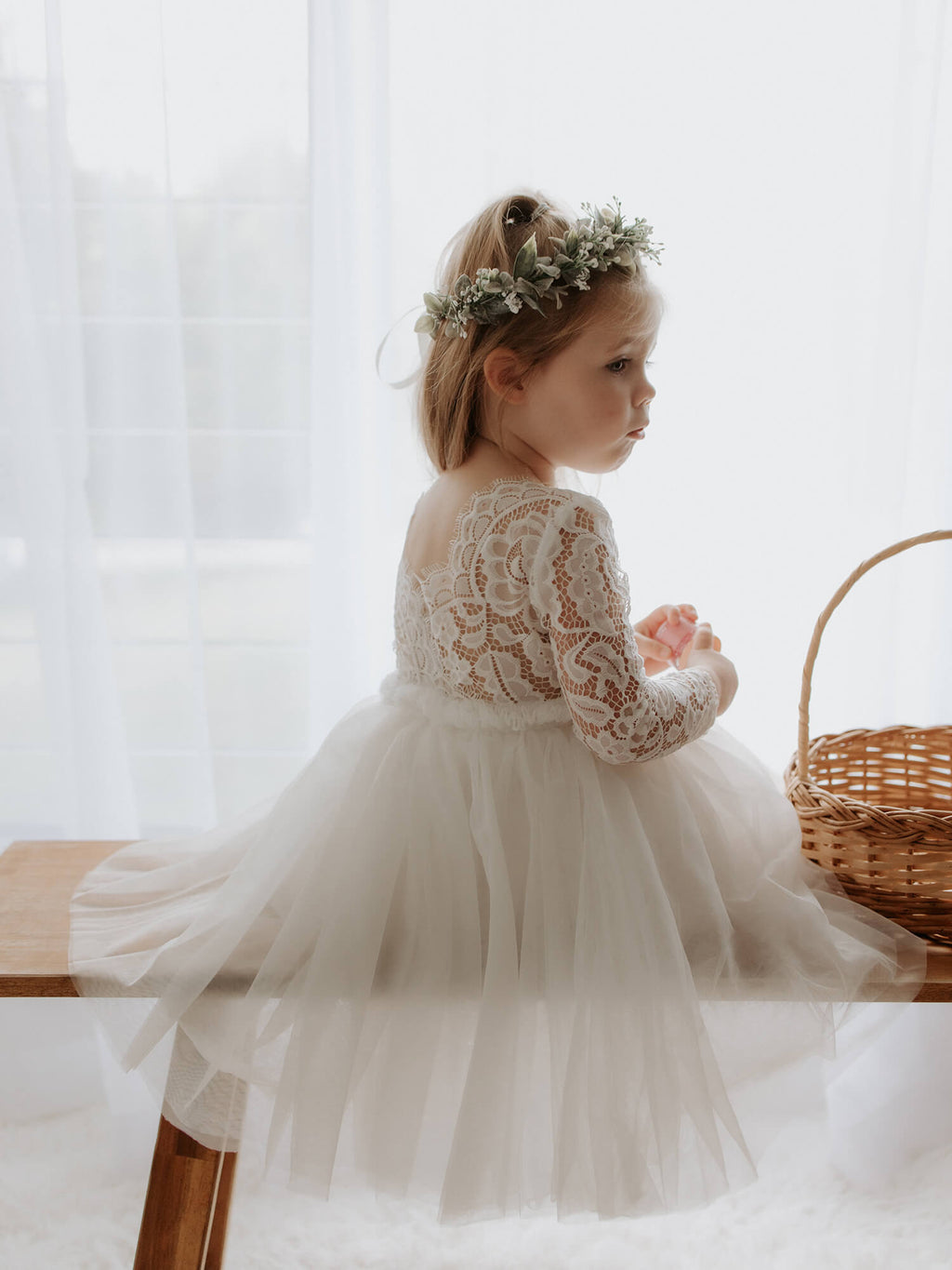Belle tea length flower girl dress in ivory is worn by a toddler.