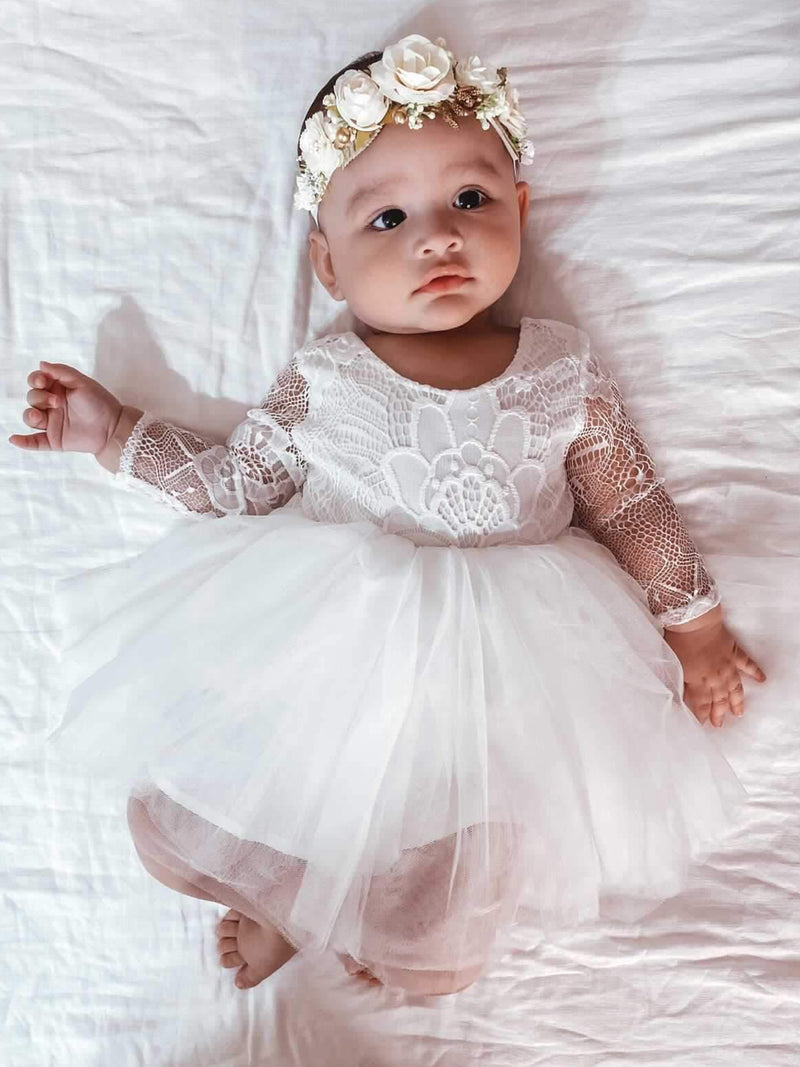 Briar lace flower girl dress is worn by a baby, along with our Sage baby floral headband.