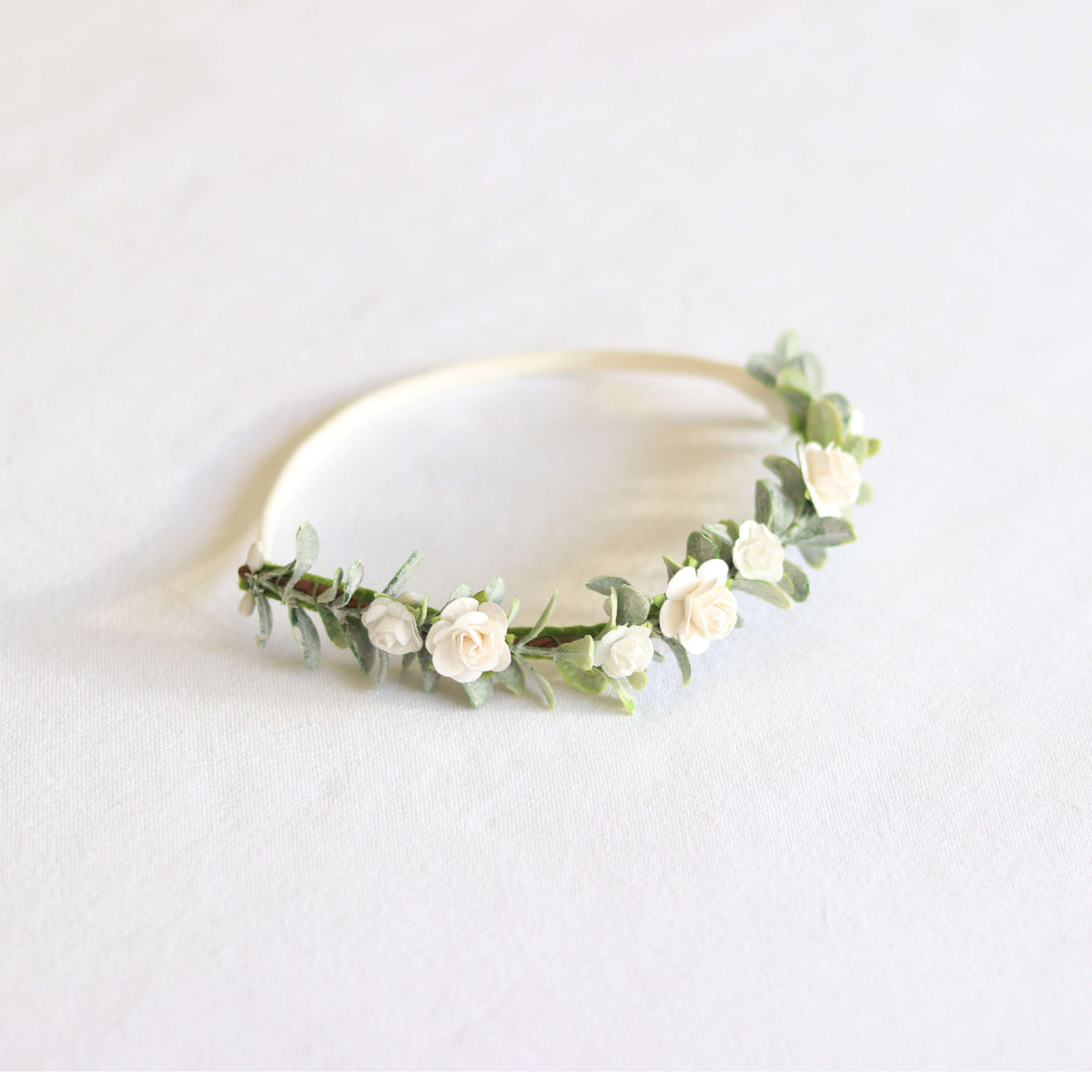 Side view of Eden floral headband. This special occasion flower crown is neutral and beautiful with greenery and small ivory roses.