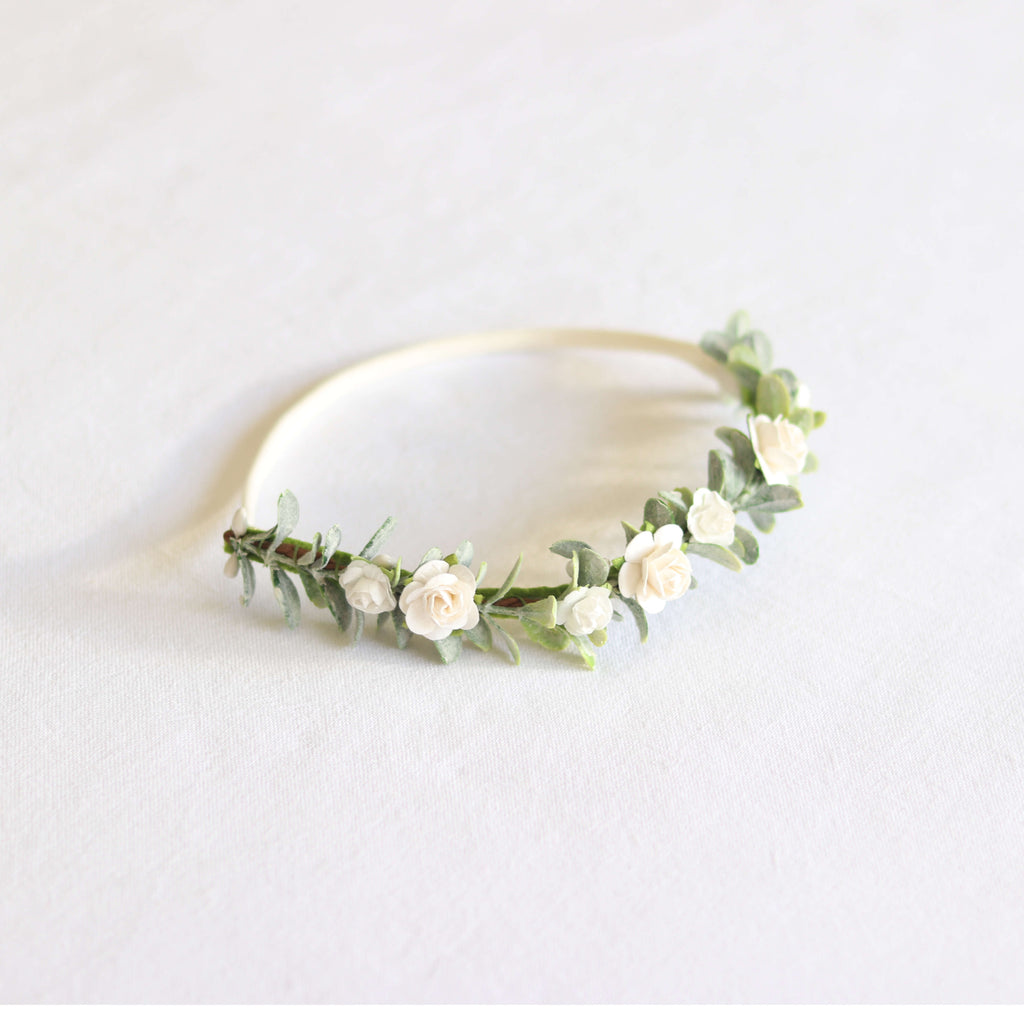 Eden toddler and girls ivory floral headband. Dainty ivory flowers spaced along a base of greenery, a simple neutral flower crown. Set on a soft elastic cream headband.