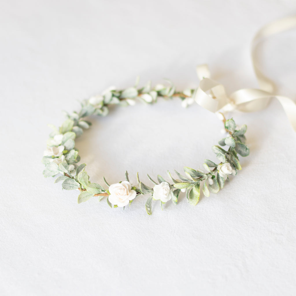 Eden ivory flower crown with small ivory roses on wreath of greenery, with an ivory ribbon.