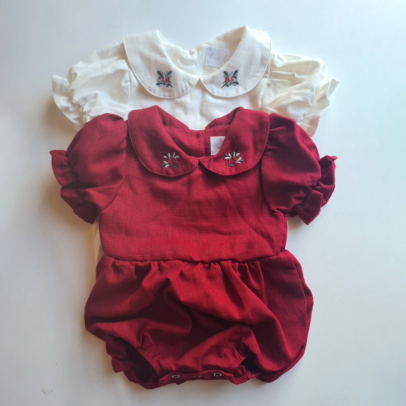 Emma Christmas romper flat lay showing ivory and crimson Christmas rompers.