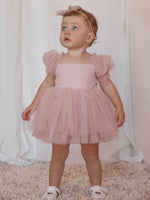 Gabrielle baby flower girl romper with tulle puff sleeves in dusty pink, worn by a toddler along with our tulle bow headband in dusty pink.