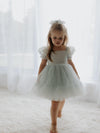 Gabrielle dusty blue flower girl dress with tulle puff sleeves, is worn by a young girl, she also wears a tulle bow in her hair.