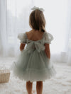 A young girl wears our Gabrielle flower girl dress, showing the tulle bow at the back.