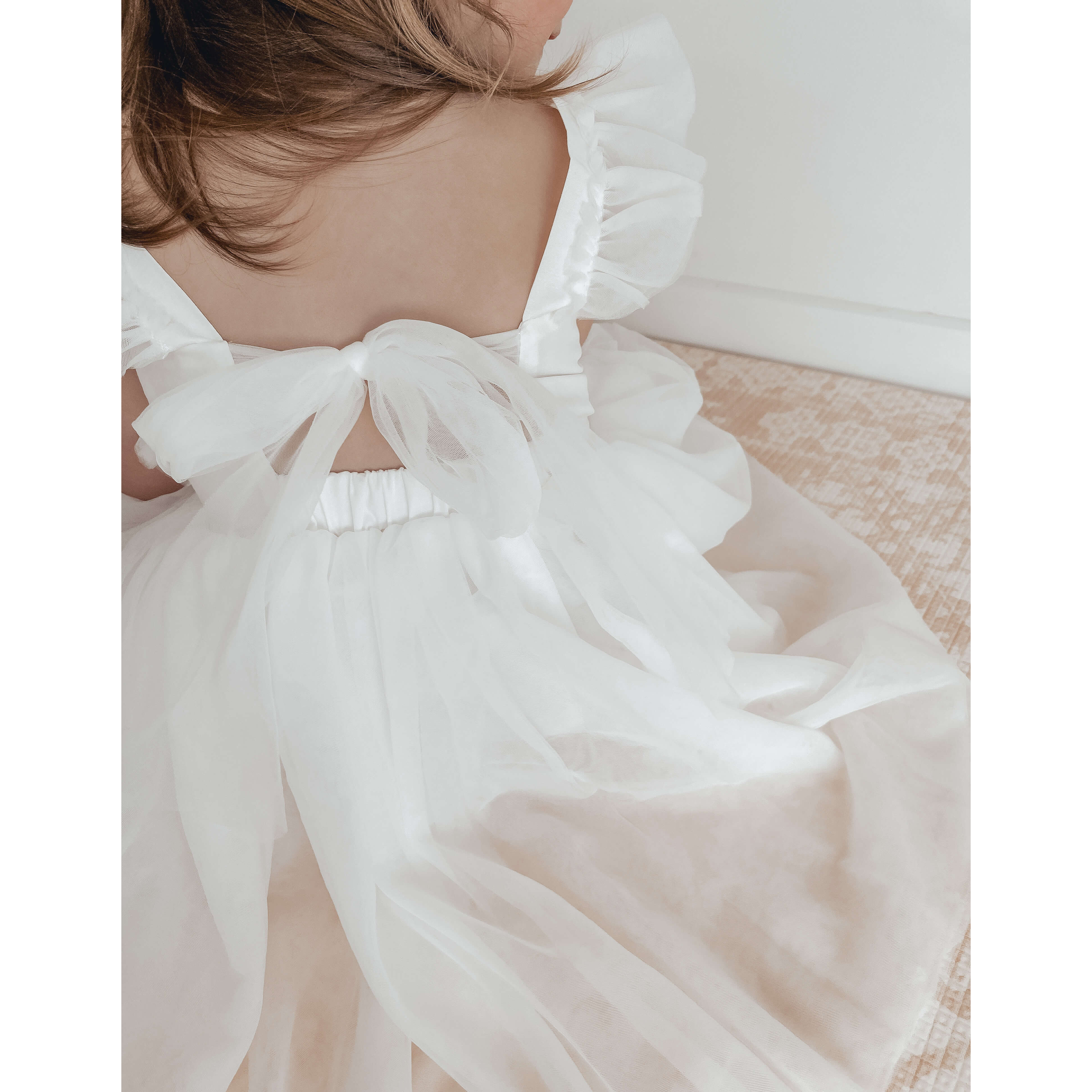 Gigi flower girl dress is shown from the back, showing the tulle bow at the back of the dress.