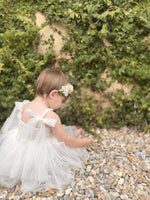 Harper ivory baby flower girl romper showing the tulle tie straps and shirred back.