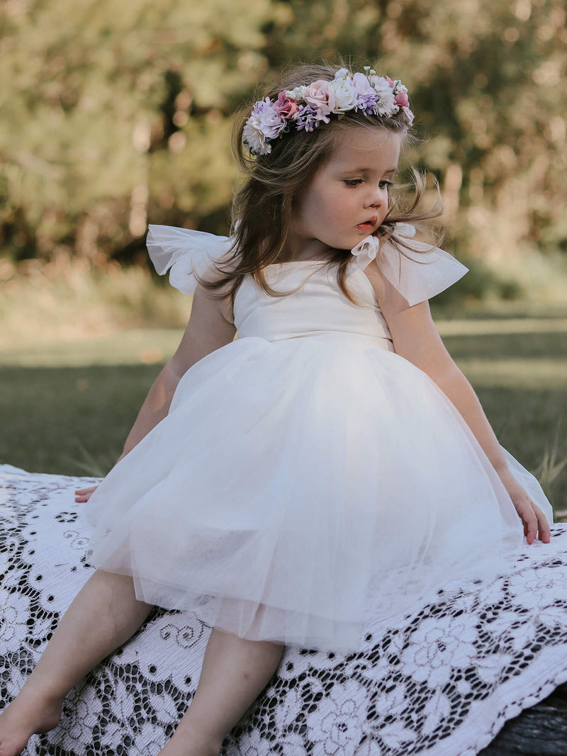Harper light ivory flower girl dress is worn by a young girl, along with our Luna girls flower crown.