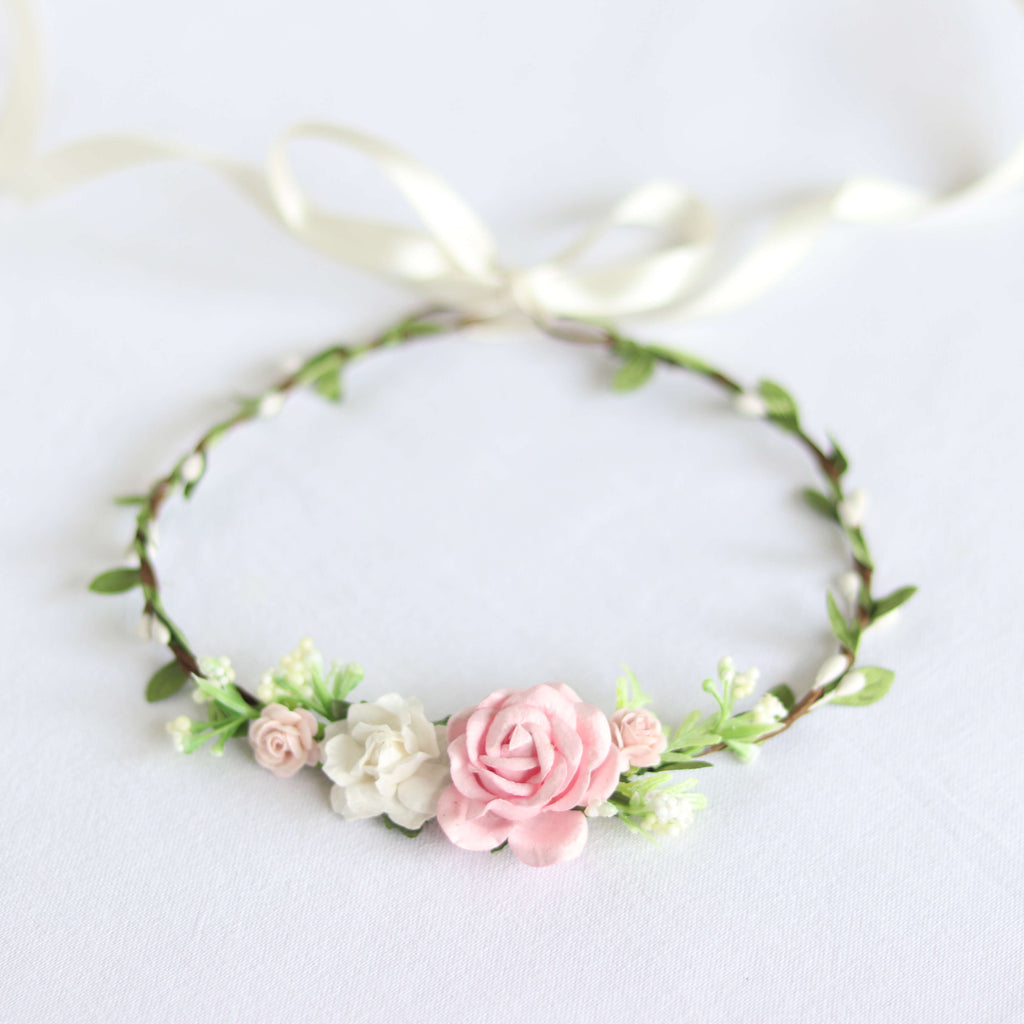 Layla girls dusty pink flower crown. Showing a central small dusty pink rose, surrounded by smaller pink and ivory flowers and greenery. A dainty tie back flower crown with an ivory ribbon.