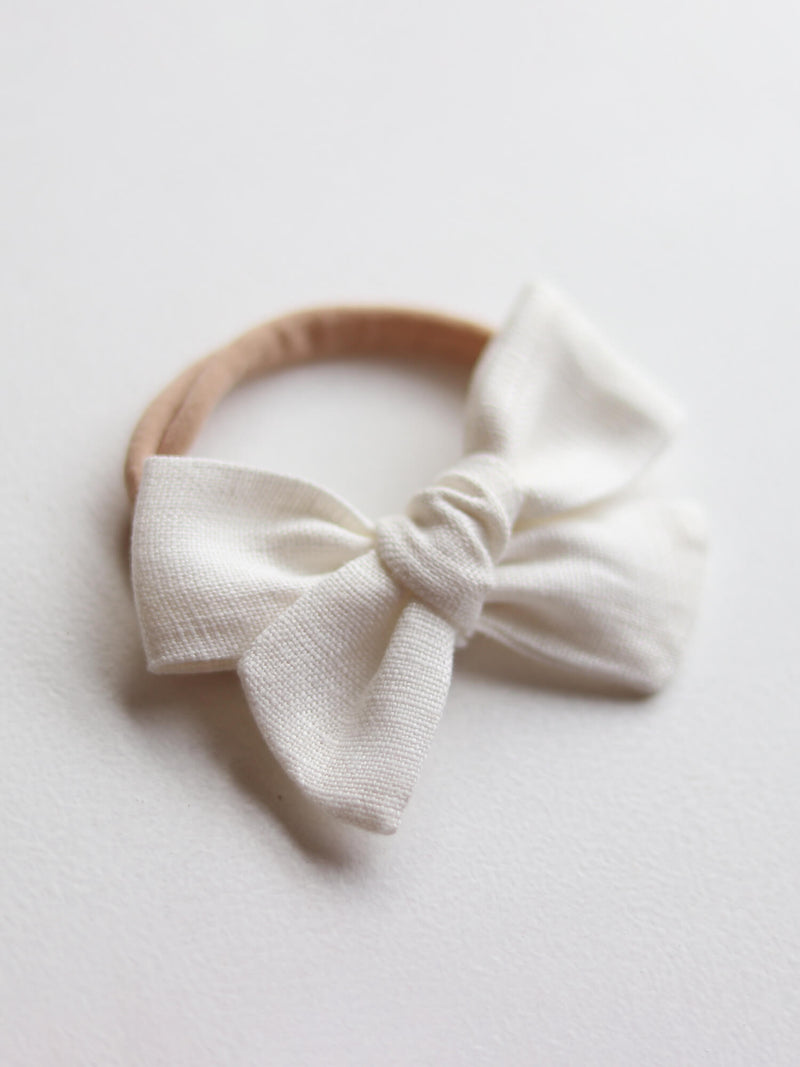 Ivory linen bow headband on a soft headband, to match baby flower girl outfit.