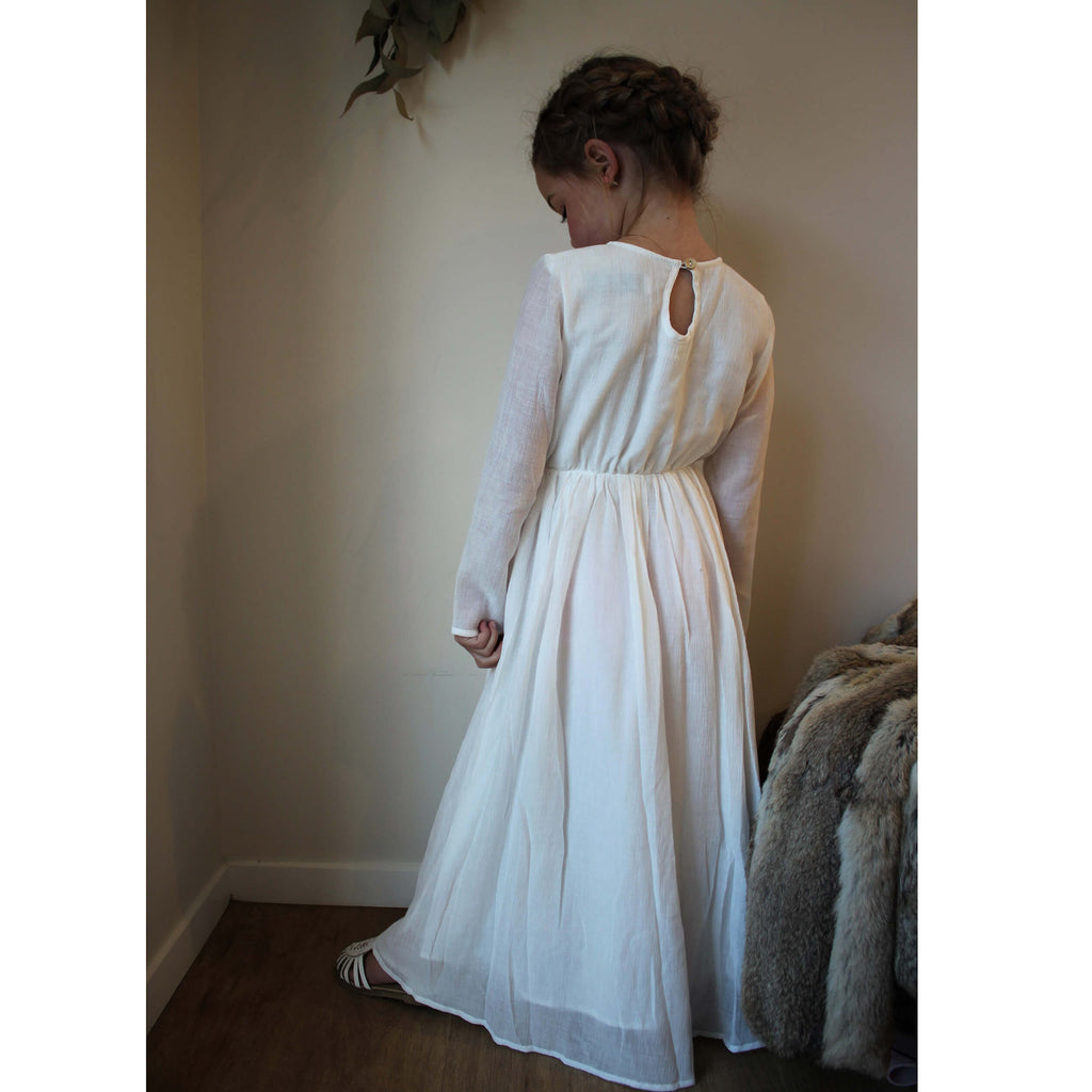Marlowe full length long sleeve ivory flower girl dress being worn by a young girl..