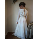 Marlowe winter flower girl dress is worn by a young girl, shown from the back.