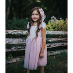 Flower girl wears our Rosie dusty pink flower girl dress and matching tulle bow.