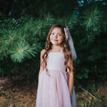 Rosie dusty pink flower girl dress is worn by a young girl.