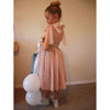 Rosie girls party dress or flower girl dress shown on a young girl. Shows the tulle tie straps and shirred bodice.