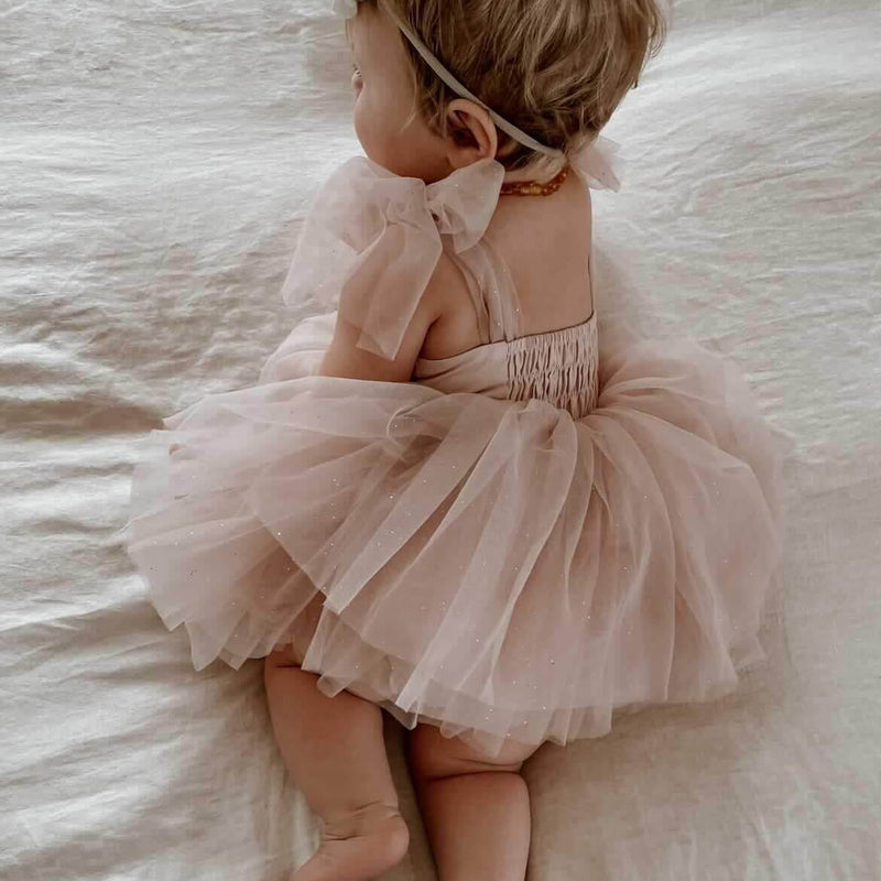 Rosie tulle baby romper shown from the back, showing the shirring at the back, on a baby girl.