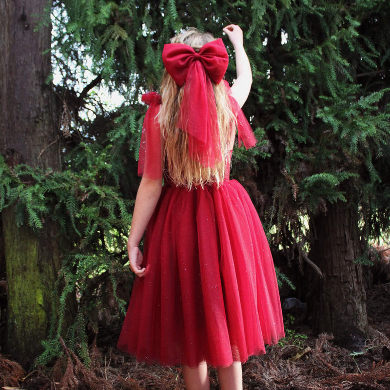 Crimson red tulle bow is worn by a young girl, along with our Rosie christmas dress.