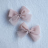 Small pigtail tulle bows in dusty pink.