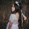 Sophia blush flower girl dress being worn by a young girl. She also wears our Amelie girls flower crown in blush. The flower girl dress has an ivory lace back and a blush full length tulle skirt.
