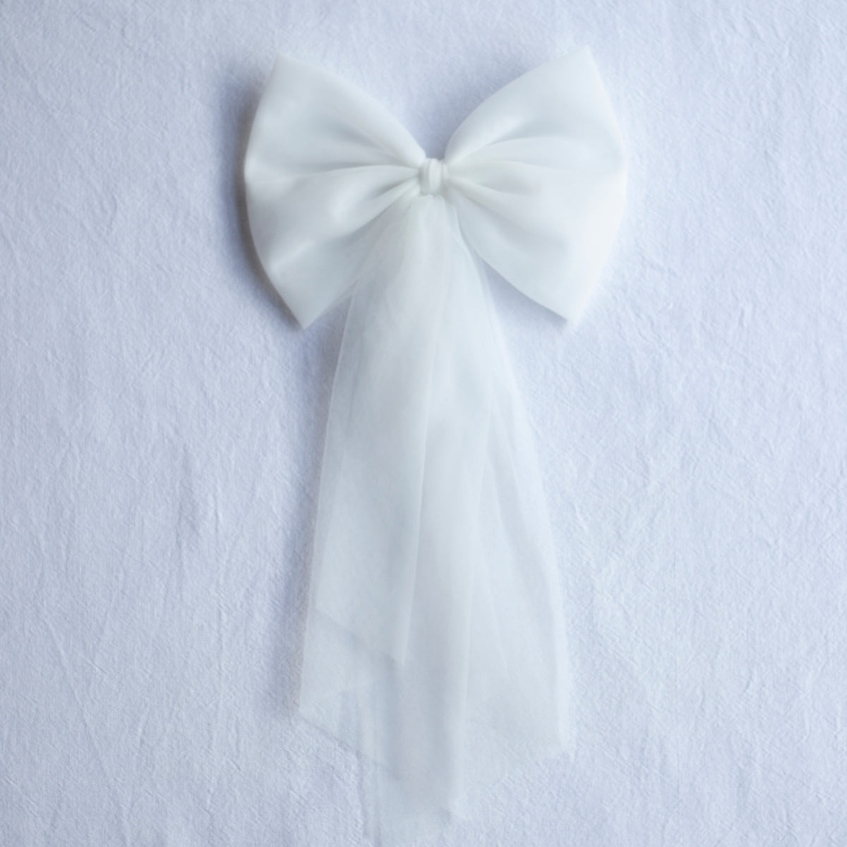 Large tulle bow clip in ivory with long tulle tails. Perfect to match a flower girl dress or girls party dress.